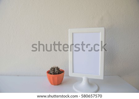 photo White Frame and cactus on a wooden on wall background .