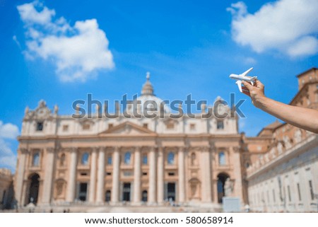 Closeup toy airplane on St. Peter's Basilica church in Vatican city background. Concept of travel imagination.
