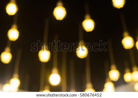 abstract blurred yellow lamp light hanging from ceiling wall interior modern room decoration concept.