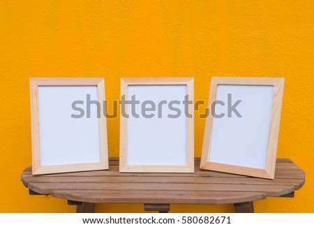 three photo Frame on a wooden on Yellow background .