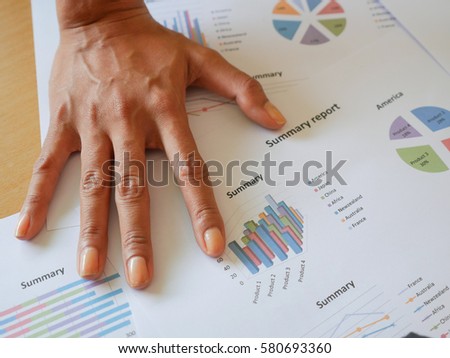 Right hand of sales manager place on business reports.Very serious situation.