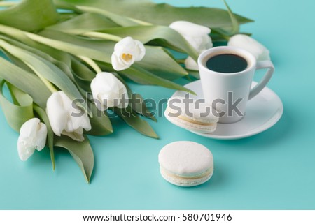 Breakfast with coffee cup and white tulips on plain background