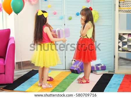 Birthday celebrating. Girls with gift box in room