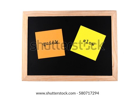 orange and yellow paper with "quick" and "slow" words on black board