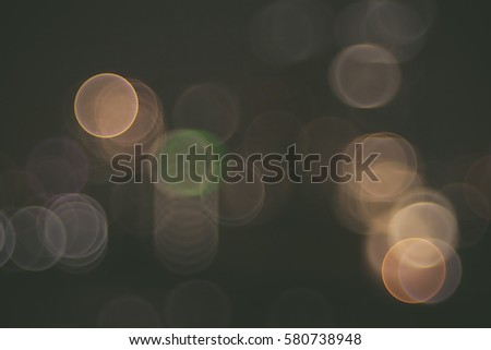 Lights blurred bokeh background from city in the night. In vintage or retro color toned