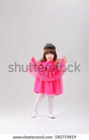 beautiful little girl in pink Princess dress with crown on gray 