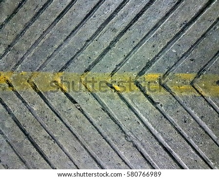 yellow line center and arrow sign concrete sidewalk for background Royalty-Free Stock Photo #580766989
