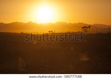 Beautiful sunset in desert on the border of New Mexico and Arizona, with billboards in the background; high temperature