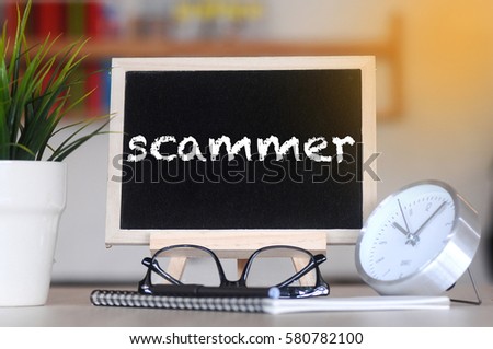 concept of coffee cup with stand board on blurred modern office background with SCAMMER words. tone image