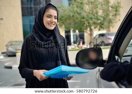 Emarati Arab Business women getting into the car in Dubai, United Arab Emirates.