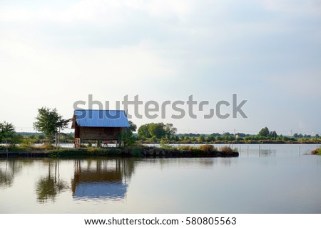 Landscape lake with cottage house village. relaxation waterfront hut in countryside  Royalty-Free Stock Photo #580805563