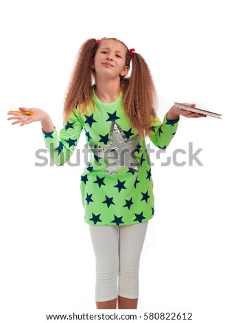 Young girl with long hair in a green tunic with a star with a notebook and pen for notes on a white background posing in the studio

