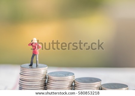 Business, Money, Saving and Communication Concept. Businessman with mobile phone miniature figure standing on top of the stack of coins