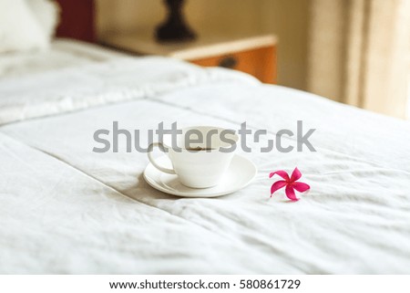 cup of tea and flower on the bed