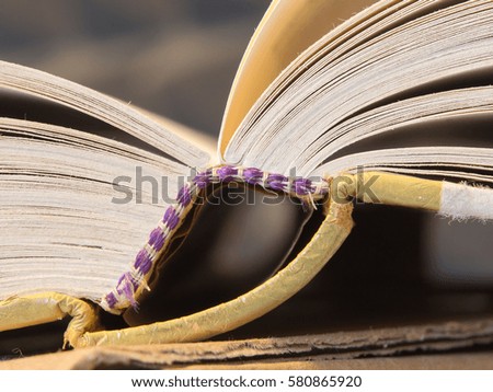 closeup of an open dirty worn hardcover book in soft focus