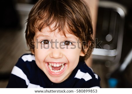 Portrait of happy child toddler boy smiling and laughing close up Royalty-Free Stock Photo #580899853