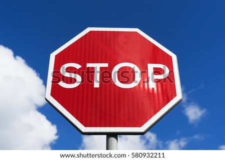 Red Stop Sign with Blue Sky and Clouds Background.