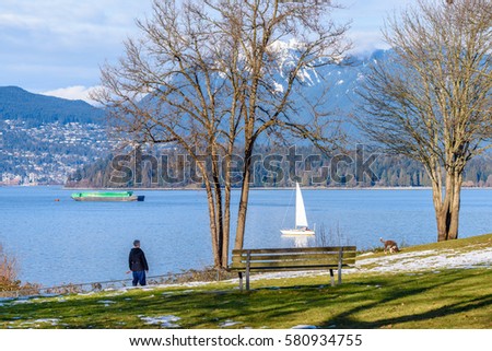 View on beautiful Vancouver park and harbour over snow mountains.