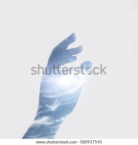 Double exposure effects on silhouette hand combined with photograph of air sky clouds in light. Conceptual, abstract. Nature, ecology, environment, earth. Save the planet. Elements Air