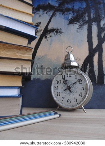 The books on the table. Clock