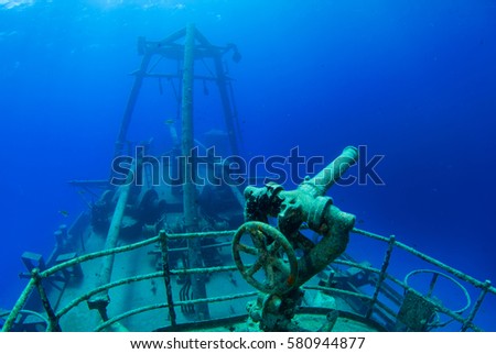 The sunken uss kittiwake sits in shallow water in Grand Cayman. This photo taken by a scuba diver focusses on the aft section of the vessel including the railings, water cannon and superstructure