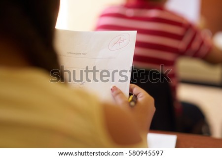 Young people and education. Group of hispanic students in class at school during lesson. Good grade for smart student on test Royalty-Free Stock Photo #580945597