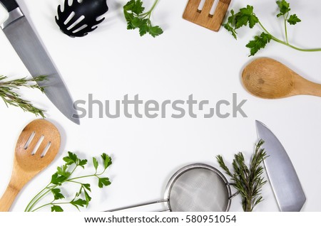 Concept idea for advertising or presentation in food industry, menus, brochures for restaurants. Copy space or room for text on white background, with kitchen utensils and parsley leaves scattered. Royalty-Free Stock Photo #580951054