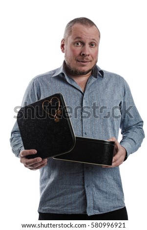 emotional actor man in a gray shirt with a large black box in his hands, on a white background in studio