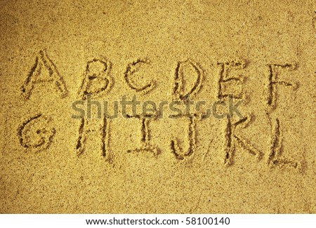 alphabet letters  handwritten in sand on beach Royalty-Free Stock Photo #58100140