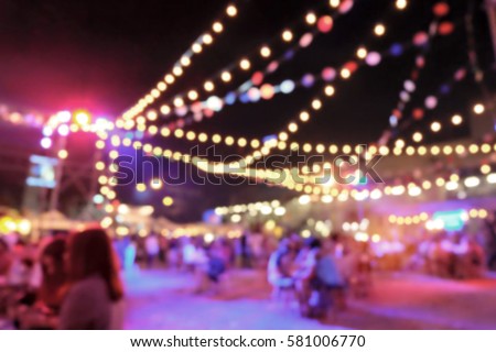 Light bokeh of people sitting at outdoor concert event with string light Royalty-Free Stock Photo #581006770
