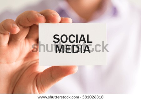Closeup on businessman holding a card with text SOCIAL MEDIA, business concept image with soft focus background