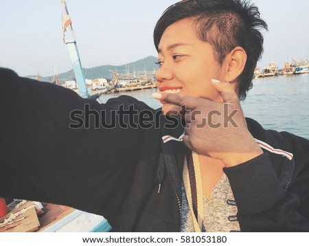 Woman taking a selfie with fishing boat