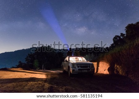 Two Man is standing in the Car Pickup  and pointing the Milky Way