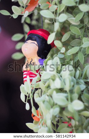clay doll and green plant