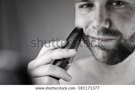 monochrome textured portrait bearded man shaving electric