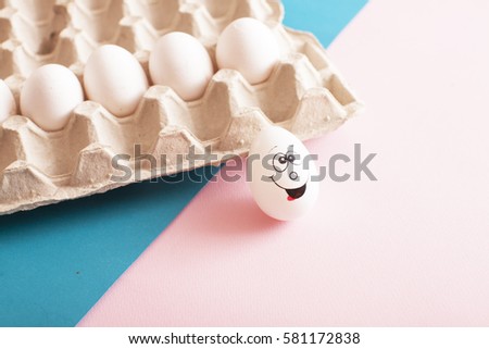 Eggs with funny faces in the package on a white background. Couple eggs with happy face for love concept.