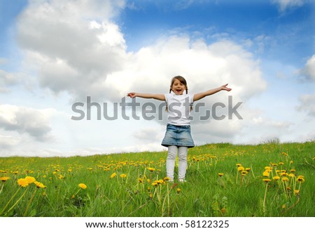Little girl standing on a meadow in a field of beautiful flower