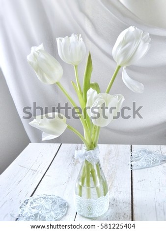 white tulips in a vase on a white table