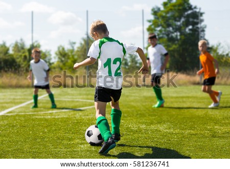 Soccer Football Players Running with Ball. Footballers Kicking Football Match on the Pitch. Young Teen Soccer Game. Youth Sports Background