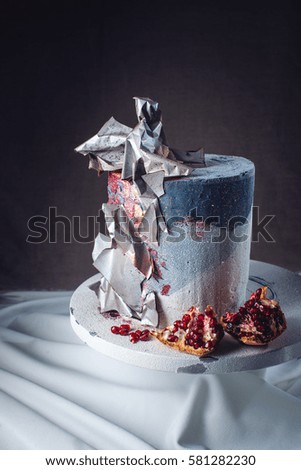 Artwork. Wedding cake decorated in loft style, decorated with metal plates and red fading. on a background of wavy fabric. food design. trends