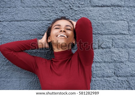 Close up portrait of beautiful young african american woman smiling with hand in hair