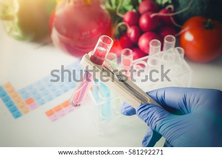 GMO Genetically modified food in lab concept. Analyst in gloves takes test tube. 