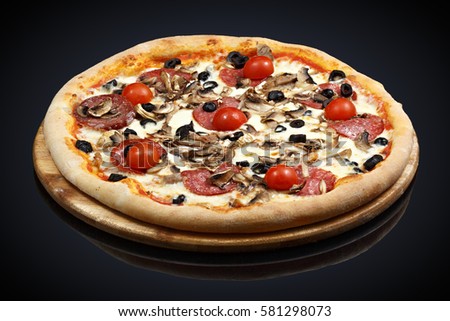Pizza with assorted meat and tomatoes on a black background
