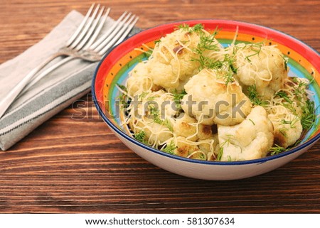 Fried cauliflower with cheese and greens. Low fat healthy eating concept.