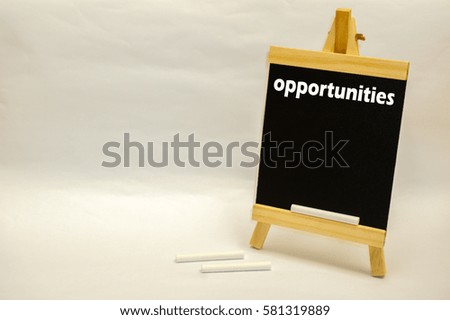 "Opportunities" word written on mini chalkboard with white chalks isolated over white background