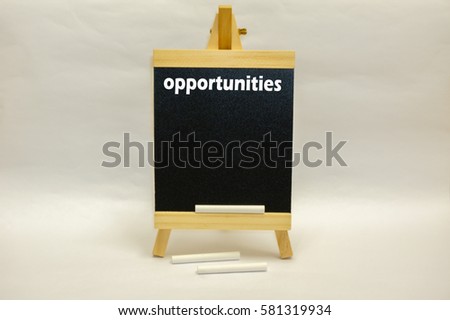 "Opportunities" word written on mini chalkboard with white chalks isolated over white background