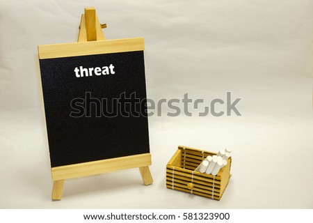Small blackboard written "threat" with white chalks inside wooden box isolated over white background