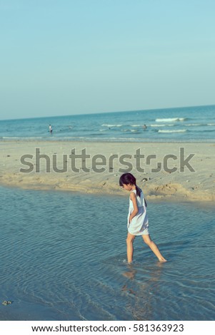Asian girl playing on the beach with sun light.
