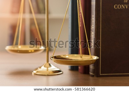 Justice and Law Concept. Scales of justice and legal book in courtroom.