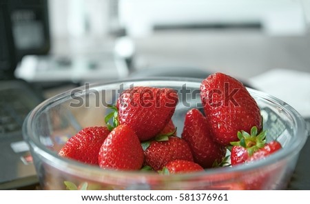 ripe red strawberry lying on the table in a glass bowl